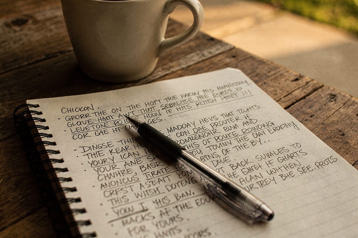 An open notebook of handwritten session notes on the studio table